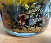 Load image into Gallery viewer, This is an image shows the making of the hair oil by infusing the herbs in the oils.